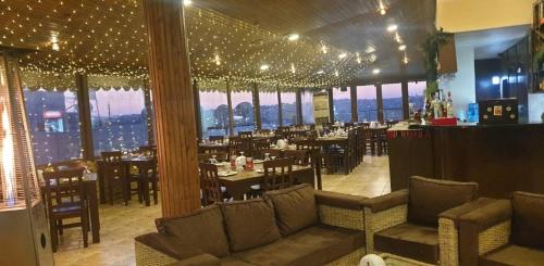 马达巴圣约翰酒店的一间设有桌椅的餐厅,位于带窗户的房间内
