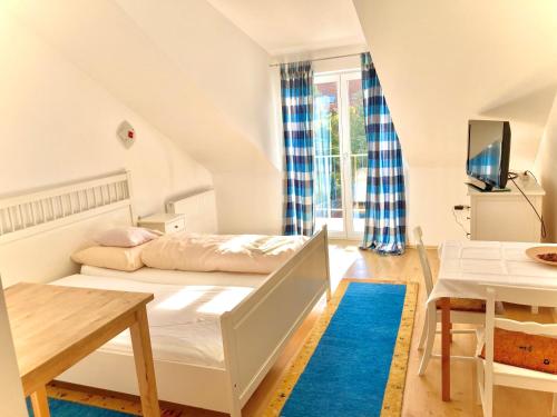 维也纳Gästezimmer Puzwidu的白色卧室配有床和桌子