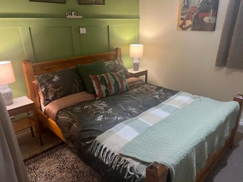 恩尼斯基林Laraghson House的一间卧室配有一张带绿色床头板的床