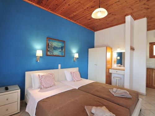 克里奥斯Vista Mare Skiathos的一间卧室设有一张蓝色墙壁的大床