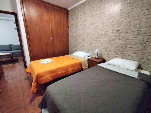 波尔图镇Apartamentos Lisboa的一间设有两张床和砖墙的房间