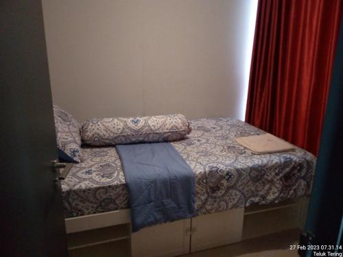巴淡岛中心Grezia at residence的一张小床,放在一个房间里,上面有笔记本电脑