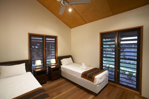 耐莉湾纯磁6号别墅的一间卧室设有两张床和窗户。