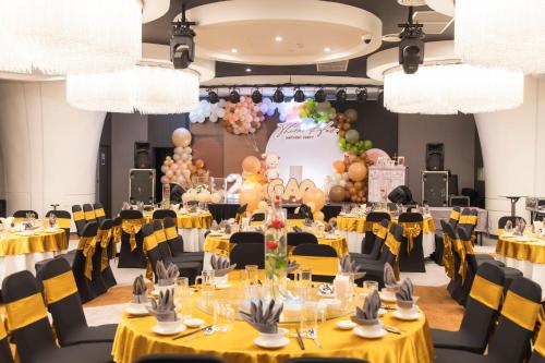 头顿Premier Pearl Hotel Vung Tau的宴会厅设有黄色桌子、椅子和气球