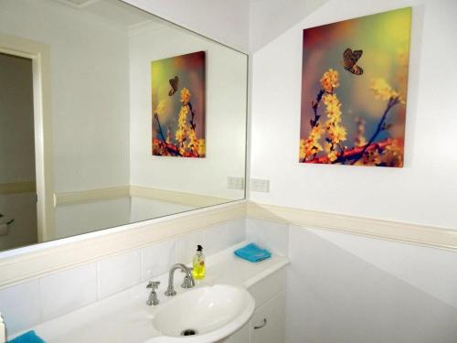 科夫斯港阿夸露娜海景度假屋的一间带水槽的浴室和墙上的两幅画
