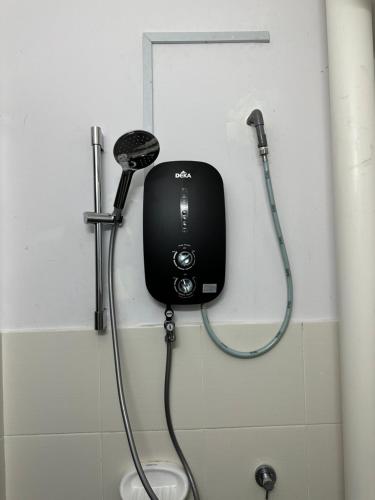 万挠Homestay Ar Rayyan RESIDENSI LAGUNA BIRU的一间带吹风机和淋浴的浴室