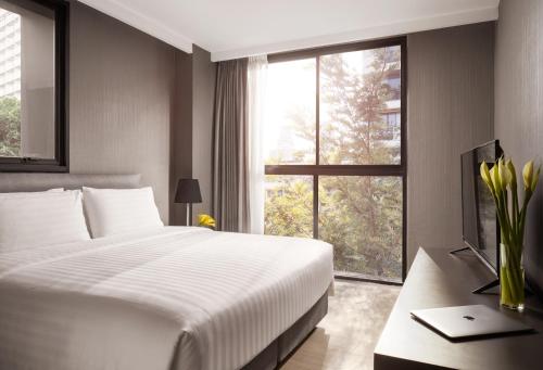曼谷曼谷素坤逸莎玛 Luxe 服务式公寓的一间卧室设有一张大床和一个窗户。
