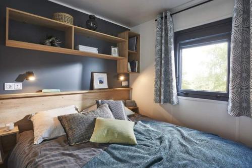莱卡巴讷Camping pays de Beille的卧室配有带枕头的床铺和窗户。