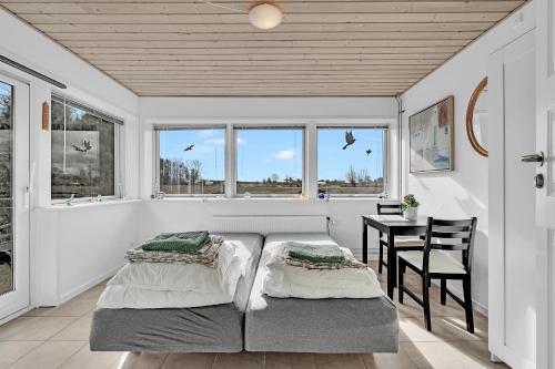 凯特明讷Guldbergs Guesthouse的卧室配有床、桌子和窗户。