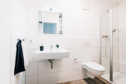 比勒费尔德Modernes Stadt-Apartement Mitte的白色的浴室设有水槽和卫生间。