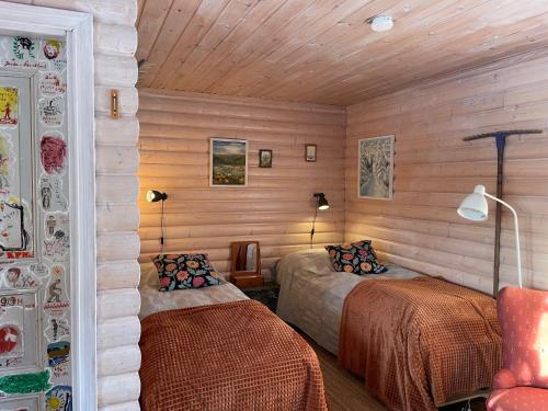 NordingråAteljéstugan med magisk utsikt的木墙客房的两张床