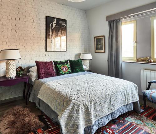 布鲁塞尔Design family 2-Bedroom House & Garden的一间卧室配有一张床、两盏灯和一个窗户。