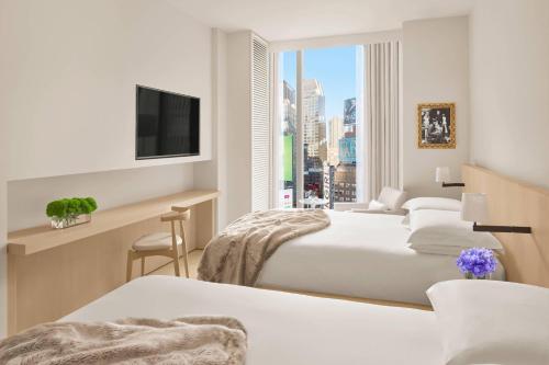 纽约The Times Square EDITION New York的一间酒店客房,设有两张床和电视