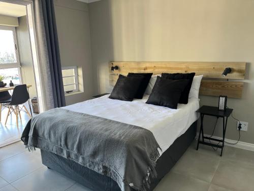 圣弗朗西斯湾Port St Francis - QuarterDeck的一间卧室配有一张大床和木制床头板