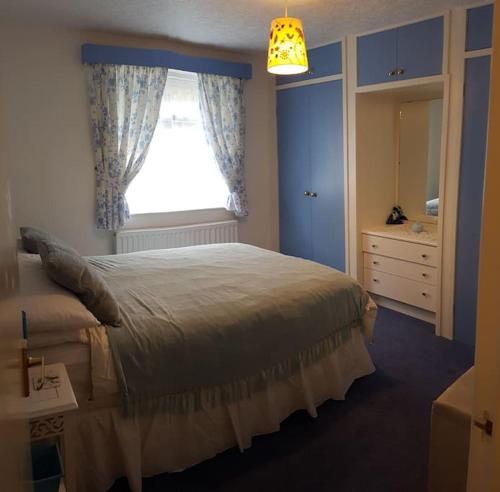 SoutergateHalsteads: peaceful location, stunning views的一间卧室配有一张带窗户和梳妆台的床