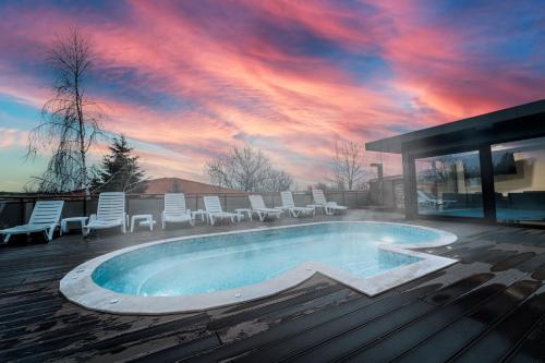 阿巴纳西纹帕拉斯酒店的一个带椅子的游泳池,日落