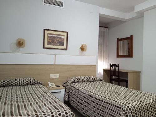 隆达皇家酒店的酒店客房配有两张床和一张桌子及椅子
