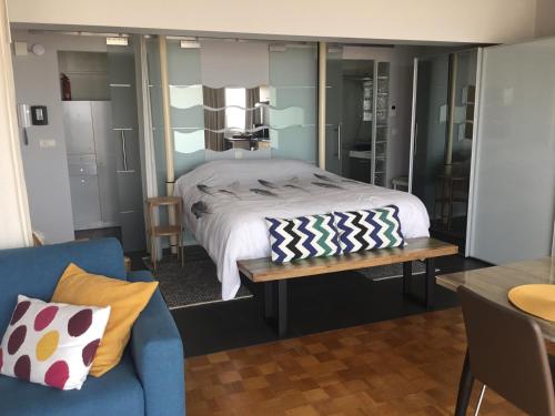 奥斯坦德Royal Zeezicht Oostende的一间卧室配有一张床和一张蓝色的沙发