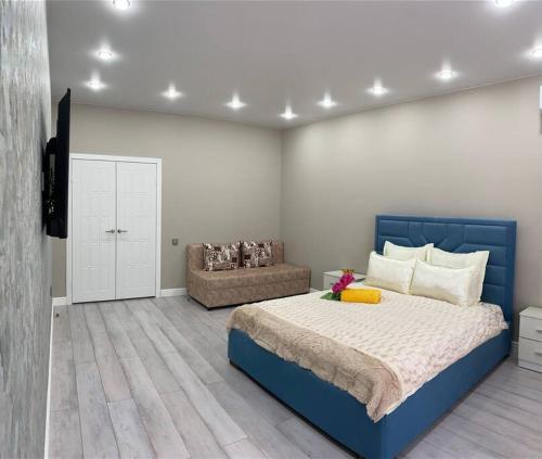 库斯塔奈VIP апартаменты в центре города的一间卧室配有蓝色的床和沙发