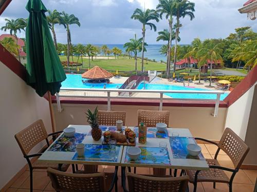 圣吕斯Appartement Madinina 6 personnes vue sur mer dans village vacances的桌椅,享有游泳池的景色