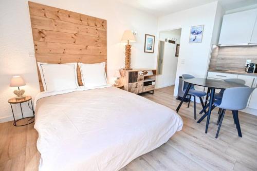 阿尔利河畔普拉兹Le balcon des neiges的卧室配有一张白色的大床和一张桌子