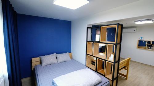 GongjuEin House的一间卧室设有一张床和蓝色的墙壁