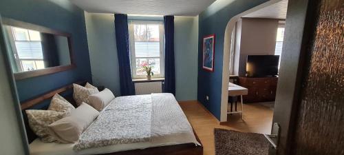 沃尔姆斯charming oldtown city的卧室配有白色的床和蓝色的墙壁