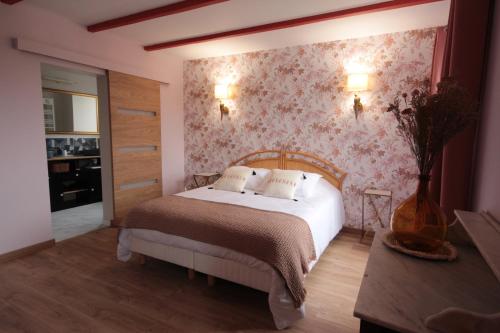 Le Manoir de Kérofil ** Gîte et chambres d'hôtes **的一间卧室配有一张带花卉壁纸的床