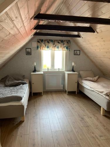 VeddigeVilla Ulvatorp nära Varberg och Ullared的阁楼卧室设有两张床和窗户。