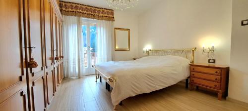 普雷达佐DolomiApartments - Casa Daria的一间卧室配有一张床、一个梳妆台和一扇窗户。