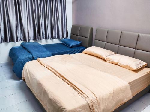 乌鲁地南Gaya Homestay 3Bed 2Bath 12pax Taman Gaya JB 5min to Aeon&Ikea 高雅民宿的一间卧室配有两张蓝色床单