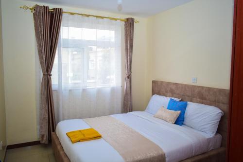 纳库鲁Havan Furnished Apartments-Milimani N8的一间卧室设有一张大床和窗户