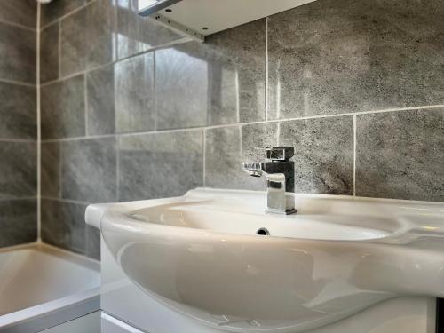 齐格威尔Modern 3 Bed Chigwell House (Free Parking)的浴室配有白色水槽和浴缸。