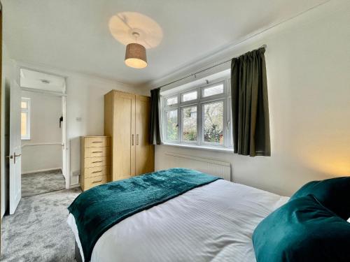 齐格威尔Modern 3 Bed Chigwell House (Free Parking)的一间卧室设有一张大床和一个窗户。