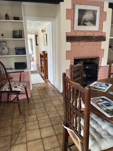 WhittleseyField Cottage的客厅设有壁炉、桌子和椅子