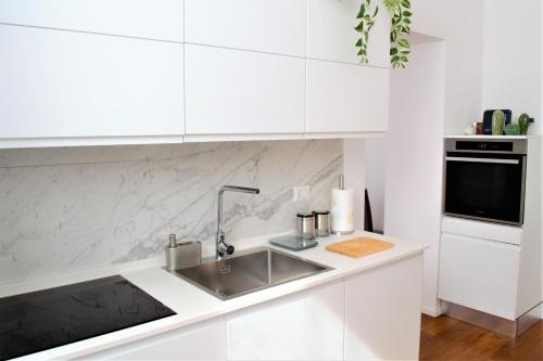 罗马Eternal City Apartment的白色的厨房配有水槽和微波炉