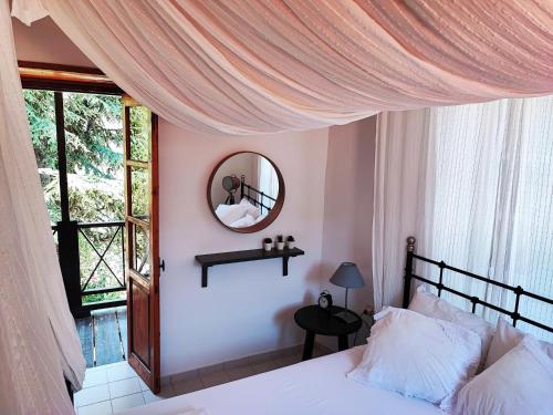 Panayia利亚科托乡村民宿的一间卧室配有一张带镜子的床和窗户