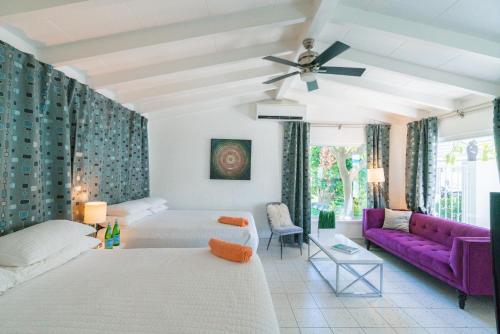 棕榈泉BelleVue Oasis - Adults Only的客厅配有一张床和一张紫色沙发