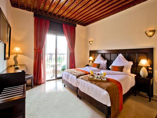 马拉喀什劳伦斯·德拉比酒店的一间卧室设有一张大床和一个大窗户