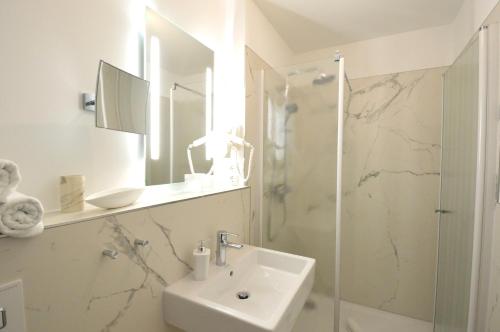 宾茨宾兹斯坦德公寓的白色的浴室设有水槽和淋浴。