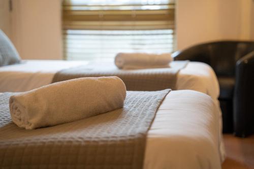 温奇尔西Winchelsea Lodge的酒店客房 - 带两张床和沙发上的毛巾