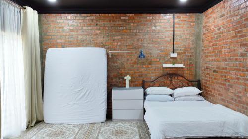 Permatang PauhStudio Amani Permatang Pauh的砖墙客房的两张床