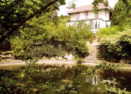 吉维尼勒普伊玫瑰酒店的房屋前有池塘的房子