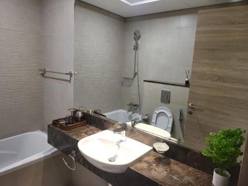 迪拜FULLY FURNISHED 2BR APARTMENT WITH MAIDS ROOM B411的浴室配有盥洗盆、卫生间和浴缸。