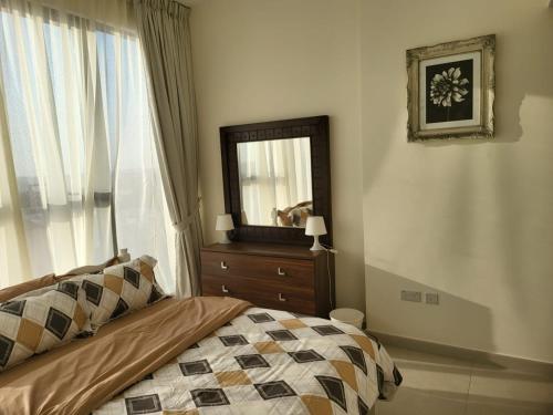 迪拜FULLY FURNISHED 2BR APARTMENT WITH MAIDS ROOM B411的一间卧室配有一张带镜子和梳妆台的床