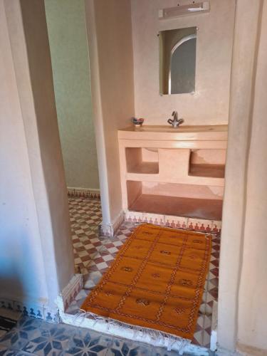 Foum ZguidRiad Assia Foum Zguid的浴室设有水槽,地板上铺有地毯。