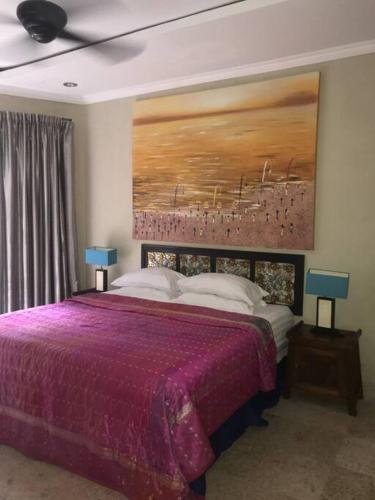 甘地达萨Spacious Private Pool Apartment-Beachside Resort的一间卧室配有一张紫色床,墙上挂有绘画作品