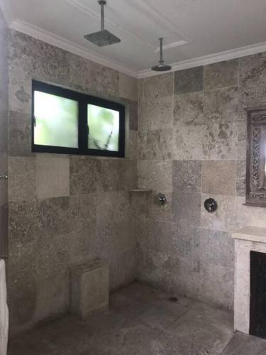 甘地达萨Spacious Private Pool Apartment-Beachside Resort的带浴缸的浴室和墙上的窗户