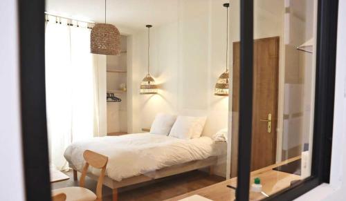 坦耶尔米塔格Charmant studio en plein coeur de Tain l'Hermitage的一间卧室配有一张带白色床单和镜子的床
