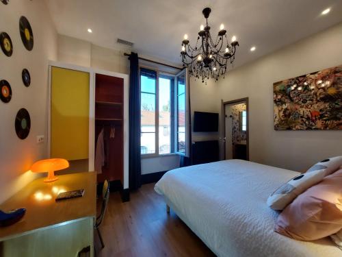 奥弗涅库尔农La Belle Epoque的一间卧室配有一张床和一个吊灯